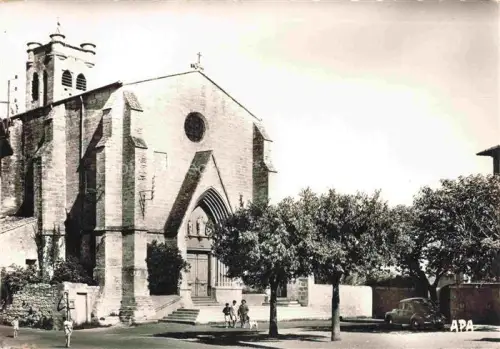 AK / Ansichtskarte Castelnau-de-Guers BEZIERS 34 Herault Eglise-XIIIe-XIVe Kirchenportal Rosette Glockenturm Passanten Auto Platanen