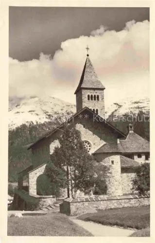 AK / Ansichtskarte Samedan Samaden GR Kath-Kirche Kirchturm Steinmauer Berglandschaft Schneeberge Engadin