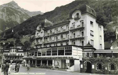 AK / Ansichtskarte Flueelen UR Hotel-Urnerhof Hotel-Schwarzer-Bock Hotel-Tell Strassenszene Berge Passanten Fahrrad