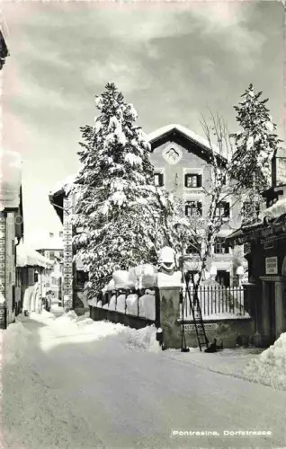 AK / Ansichtskarte Pontresina Maloja GR Dorfstrasse Winter Schnee Engadinerhaeuser Nadelbaum Strassenszene