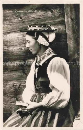 AK / Ansichtskarte Evolene Herens VS Costume-d Evolène Tracht Frau Kopfschmuck Schuerze Holzwand Portraet