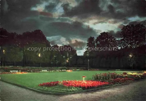 AK / Ansichtskarte Gluecksburg  Ostseebad Flensburg Schleswig-Holstein Kurgarten Nachtaufnahme Blumenbeete Rasen Beleuchtung Baeume Park