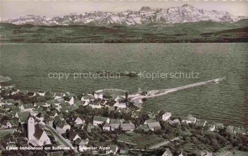 AK / Ansichtskarte Immenstaad Bodensee BW Bodensee Schweizer-Alpen Seebruecke Kirche Luftaufnahme Ortschaft Dampfer