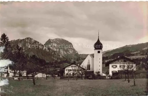 AK / Ansichtskarte Bad Feilnbach Zwiebelturm Kirche Wendelstein Bergpanorama Dorfansicht Wiese Oberbayern