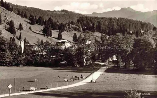 AK / Ansichtskarte Unterjoch Bad Hindelang Bayern Dorfkirche Allgaeu Bergwiese Kuehe Alpenblick Wald Bauernhof Bergdorf