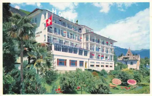 AK / Ansichtskarte Orselina Locarno TI Hotel-Orselina Palmen Bergpanorama Balkon Sonnenschirme Garten Schweizer-Fahne