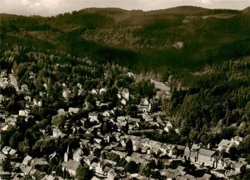 AK / Ansichtskarte Bad Sachsa Osterode Harz Niedersachsen Fliegeraufnahme Stadtpanorama Kirche Wohnhaeuser Wald Berge Harz