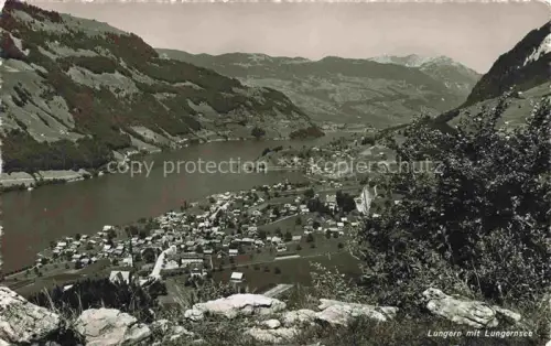 AK / Ansichtskarte Lungern Obwalden OW Lungernsee See Dorf Tal Bergkette Wiesen Wald Vogelschau