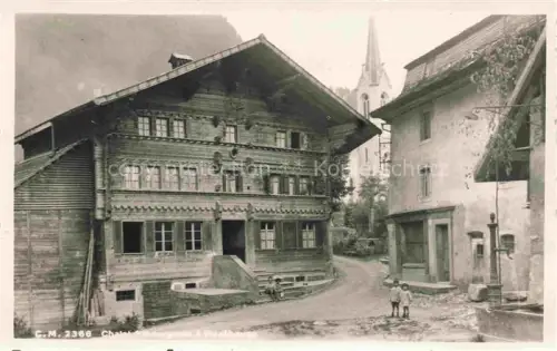 AK / Ansichtskarte Montbovon La Gruyere FR Chalet Holzhaus Dorfstrasse Kirchturm Kinder Brunnen