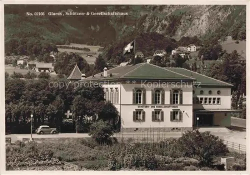 AK / Ansichtskarte GLARUS Glaris GL Schuetzen-und-Gesellschaftshaus Schweizer-Fahne Oldtimer Berge Wald Rotes-Kreuz-Fahne