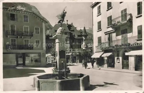 AK / Ansichtskarte Brig Glis BRIGUE VS Brunnen Statue Marktplatz Geschaefte Berge Alpen Bazar Passanten