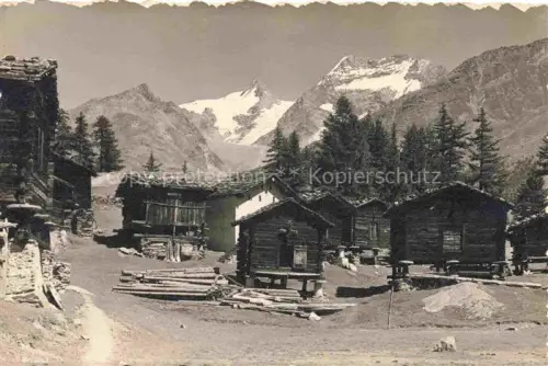 AK / Ansichtskarte Saas-Fee VISP VS Dorfpartie Fletschhorn Laquinhorn Holzhuetten Alpendorf Berge Gletscher Foehren Baumstaemme