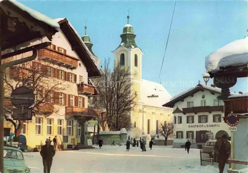 AK / Ansichtskarte St Johann Tirol AT Kirchturm Dorfplatz Gasthof-zum-Dampfl Winter Schnee Passanten Autos