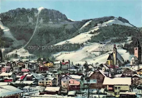 AK / Ansichtskarte Kitzbuehel Tirol AT Hahnenkamm Winterlandschaft Kirche Ort Schnee Schigebiet Skipiste Berge