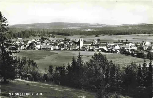 AK / Ansichtskarte Saignelegier Saingnelegier JU Stadtpanorama Kirche Wald Felder Tannen Wohnhaeuser Kirchturm