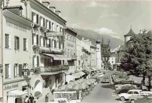 AK / Ansichtskarte LIENZ  Tirol AT Hauptplatz Hotel-Traube Julius-Meinl Photo-Dina-Mariner Geschaefte Kirchturm Berge Autos Strassenszene