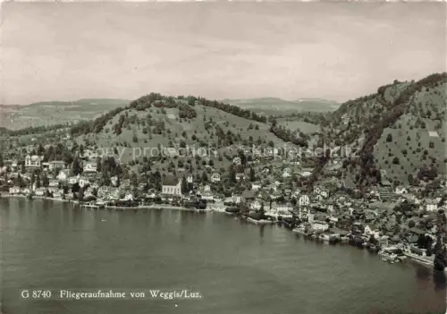 AK / Ansichtskarte Weggis Vierwaldstaettersee LU Vierwaldstaettersee Kirche Dorf Huegel Wald Fliegeraufnahme