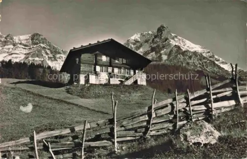 AK / Ansichtskarte Adelboden Frutigen BE Grosslohner Bauernhaus Alpen Bergwiese Holzzaun Nadelwald Schnee