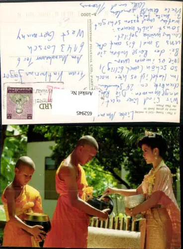 652945,A Thai Young Girl is making merit by giving foods to the Thai Priest Thailand