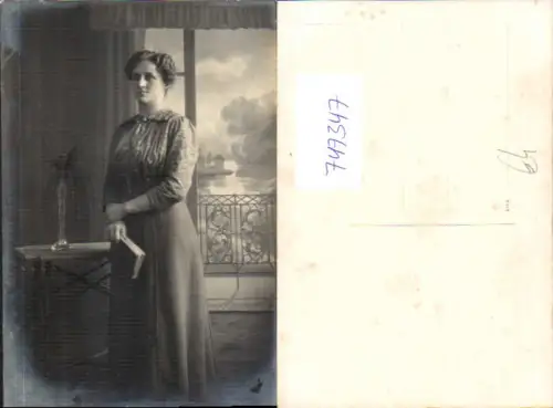 747347 Foto AK Frau mit Buch a. Stehtisch stehend