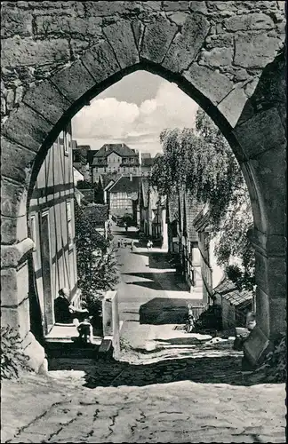 Grebenstein Straßen Partie am Burgtor, Frau sitzt vor Haus 1955