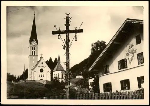Ansichtskarte Holzgau Pfarrkirche, Kreuz - bemaltes Bauernhaus 1954