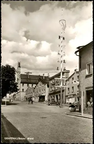 Grafenau (Niederbayern) Stadtplatz mit Maibaum; VW Käfer vor Geschäft 1960