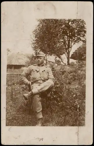 Ansichtskarte  Soldat auf Stuhl vor Gehöft, WK1 Militaria 1915