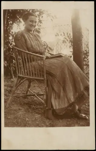 Frau in Korbsessel mit Buch im Garten am Zaun, Schleswig? 1918 Privatfoto