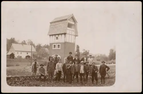 Gruppenbild Männer mit Mützen vor Turm in Dorfkulisse 1920 Privatfoto