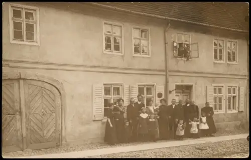 Große Personengruppe vor einem Wohnhaus mit Holztor 1910 Privatfoto