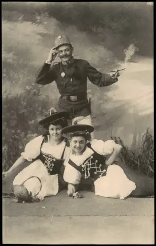Künstlerkarte - Militär Soldat mit Zigarette vor zwei Frauen in Tracht 1910